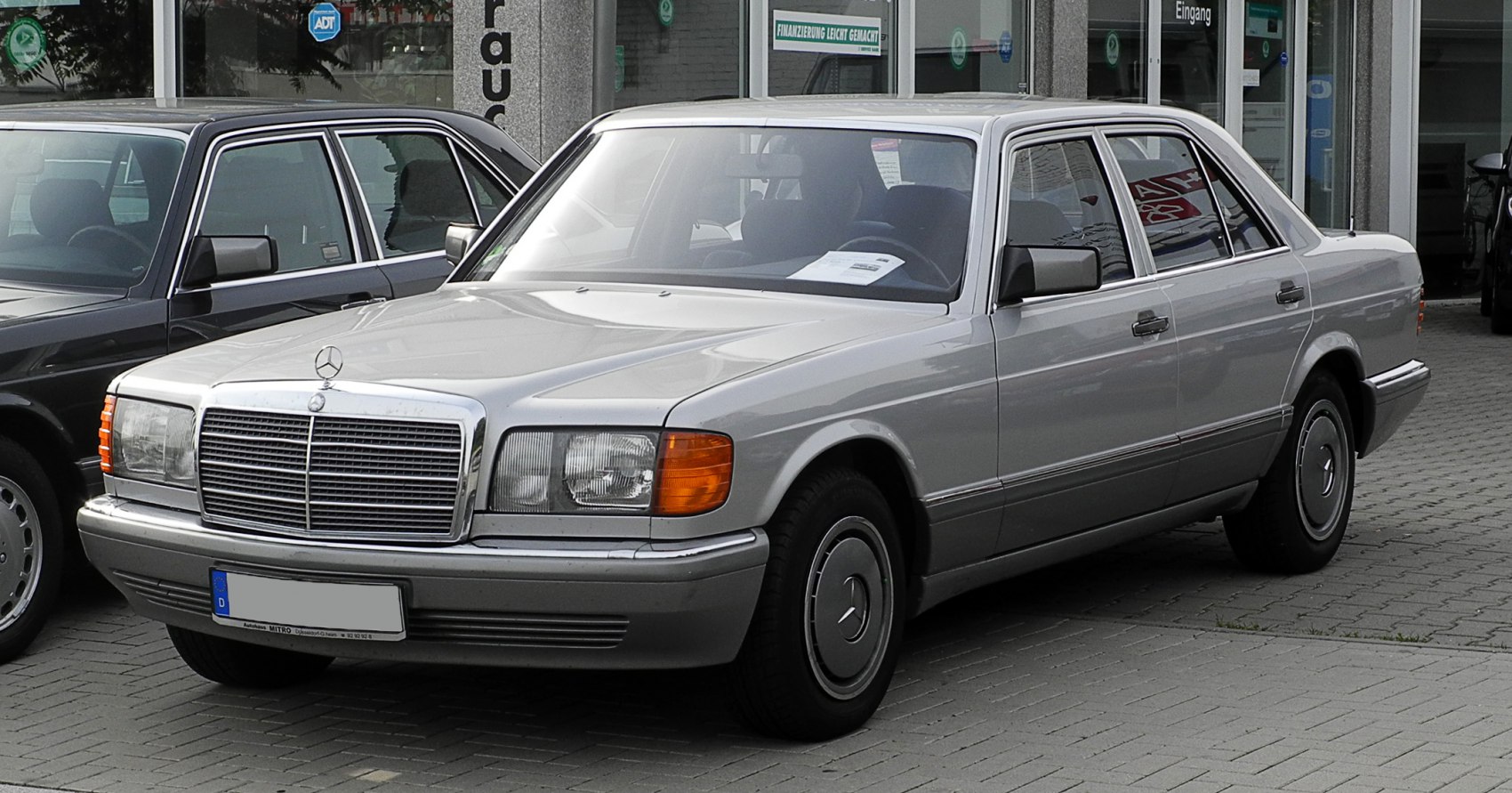 Front side view of classic luxury sedan with distinct grille and rectangular headlights
