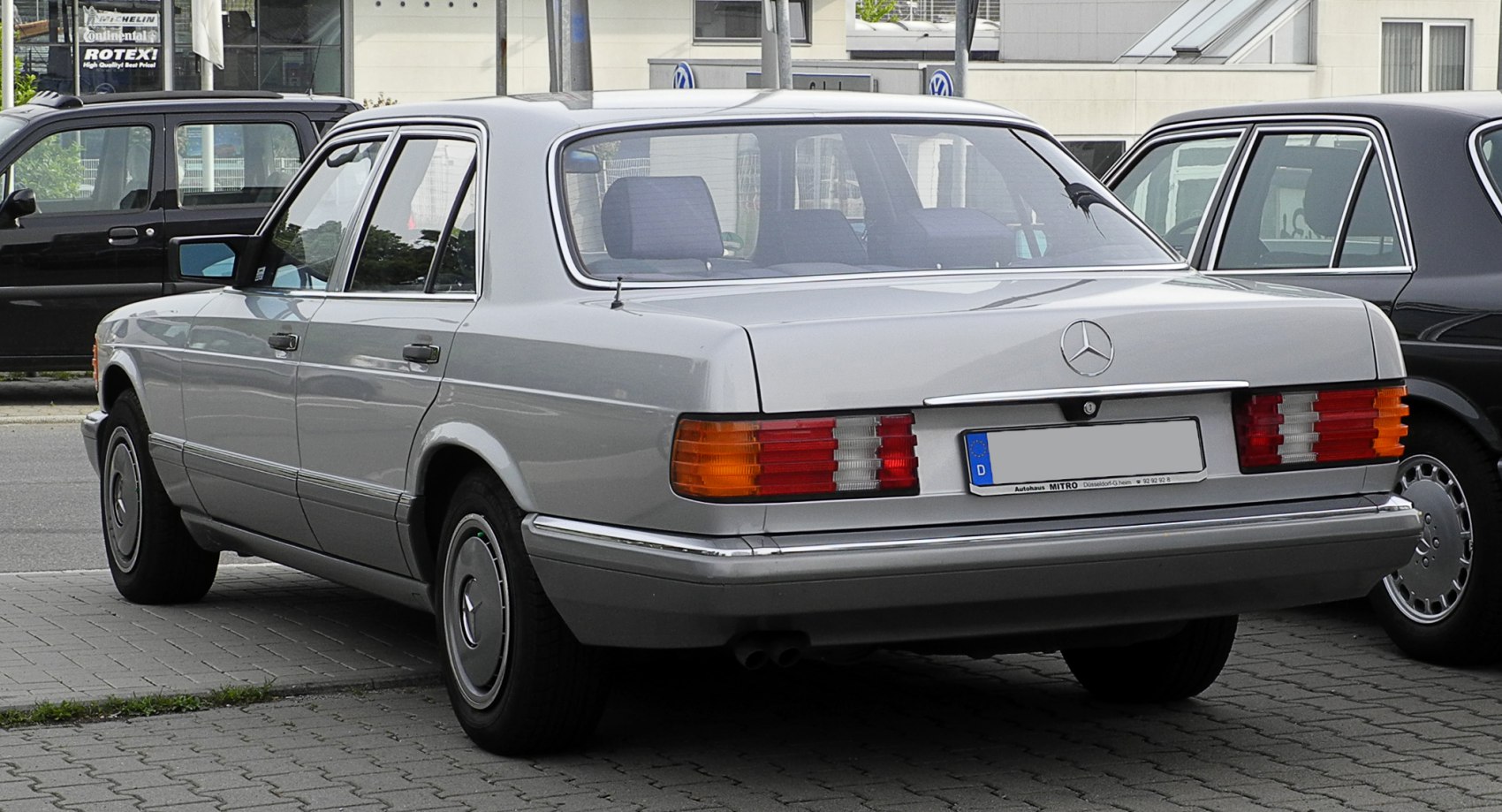 Silver sedan rear with classic taillights and chrome trim
