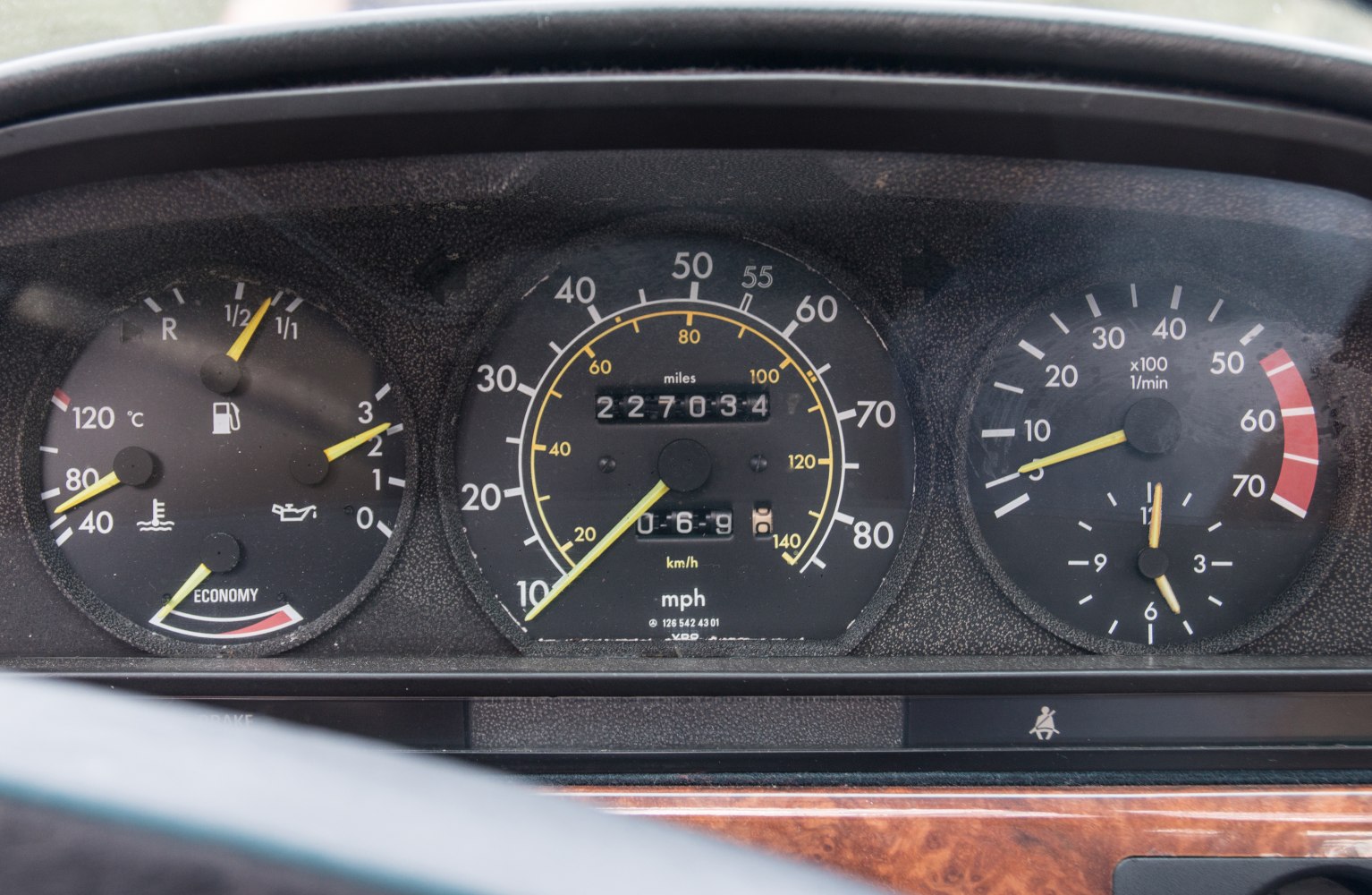 Analog dashboard gauges showing speed, RPM, fuel, and temperature meters