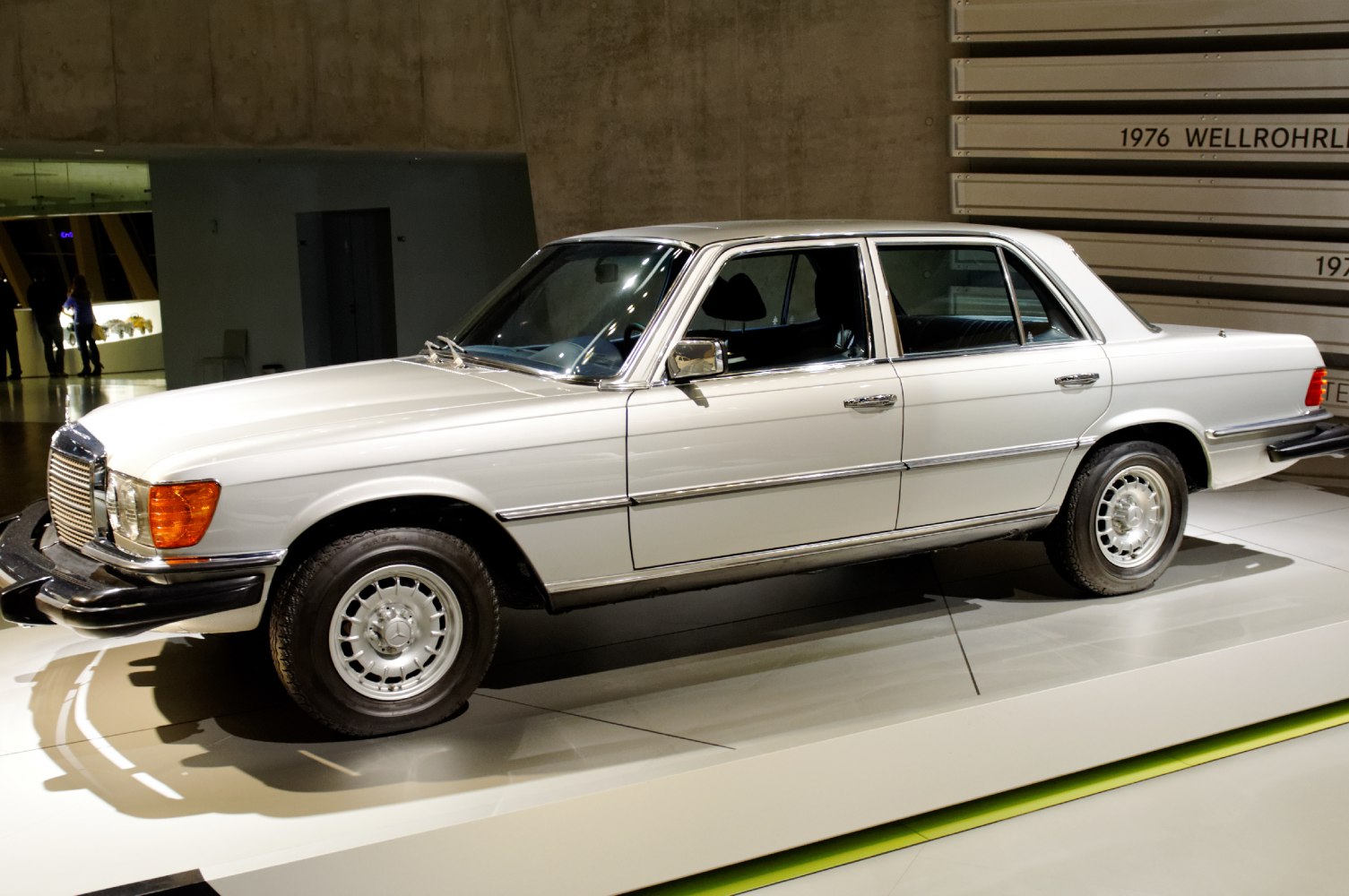 Side view of a vintage luxury sedan with chrome trim and retro wheels