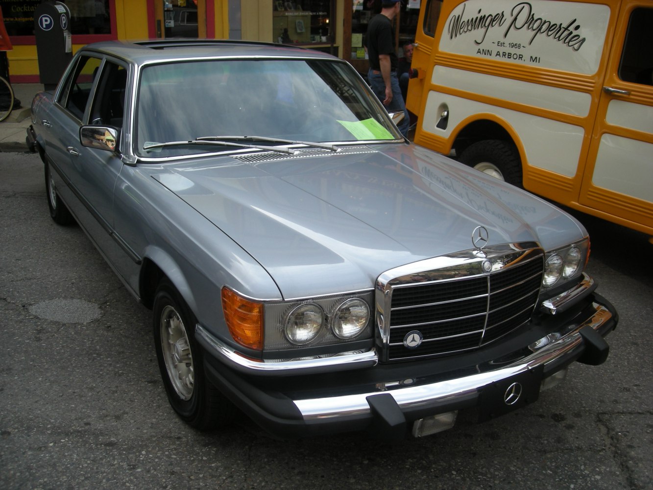 Front grille with dual round headlights and chrome bumper of a vintage sedan