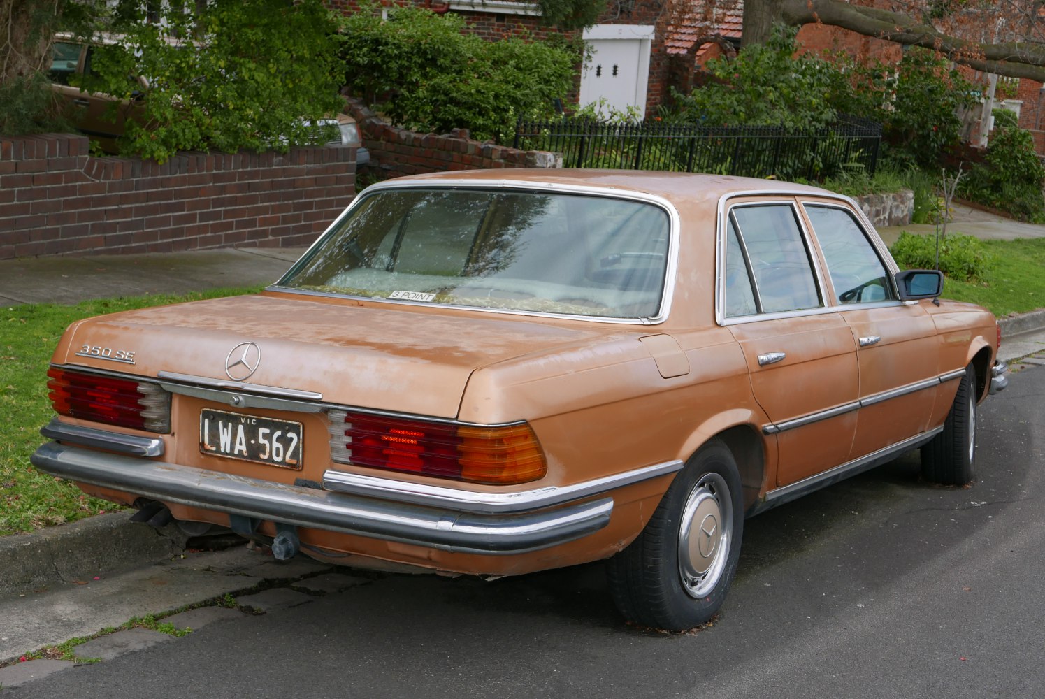 Vintage sedan rear with horizontal multi-segmented tail lights and wide chrome bumper