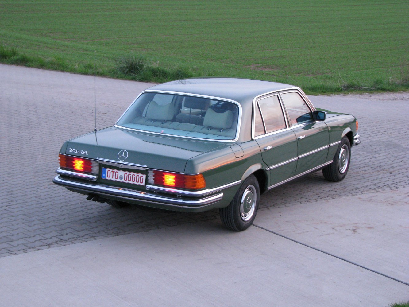 Rear view of vintage luxury sedan with brake lights illuminated