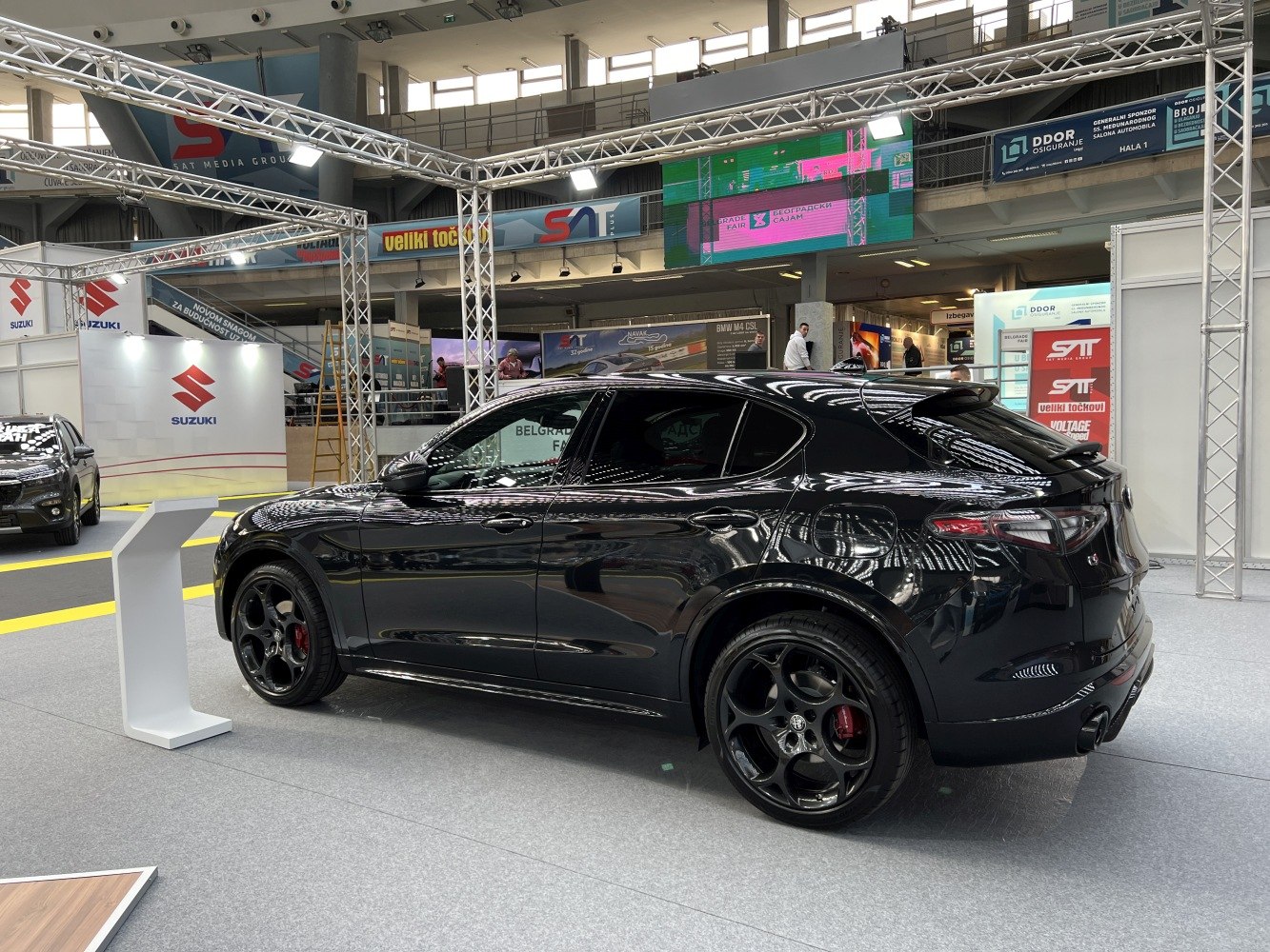 Black luxury SUV with sporty black rims, rear spoiler, and tinted windows.