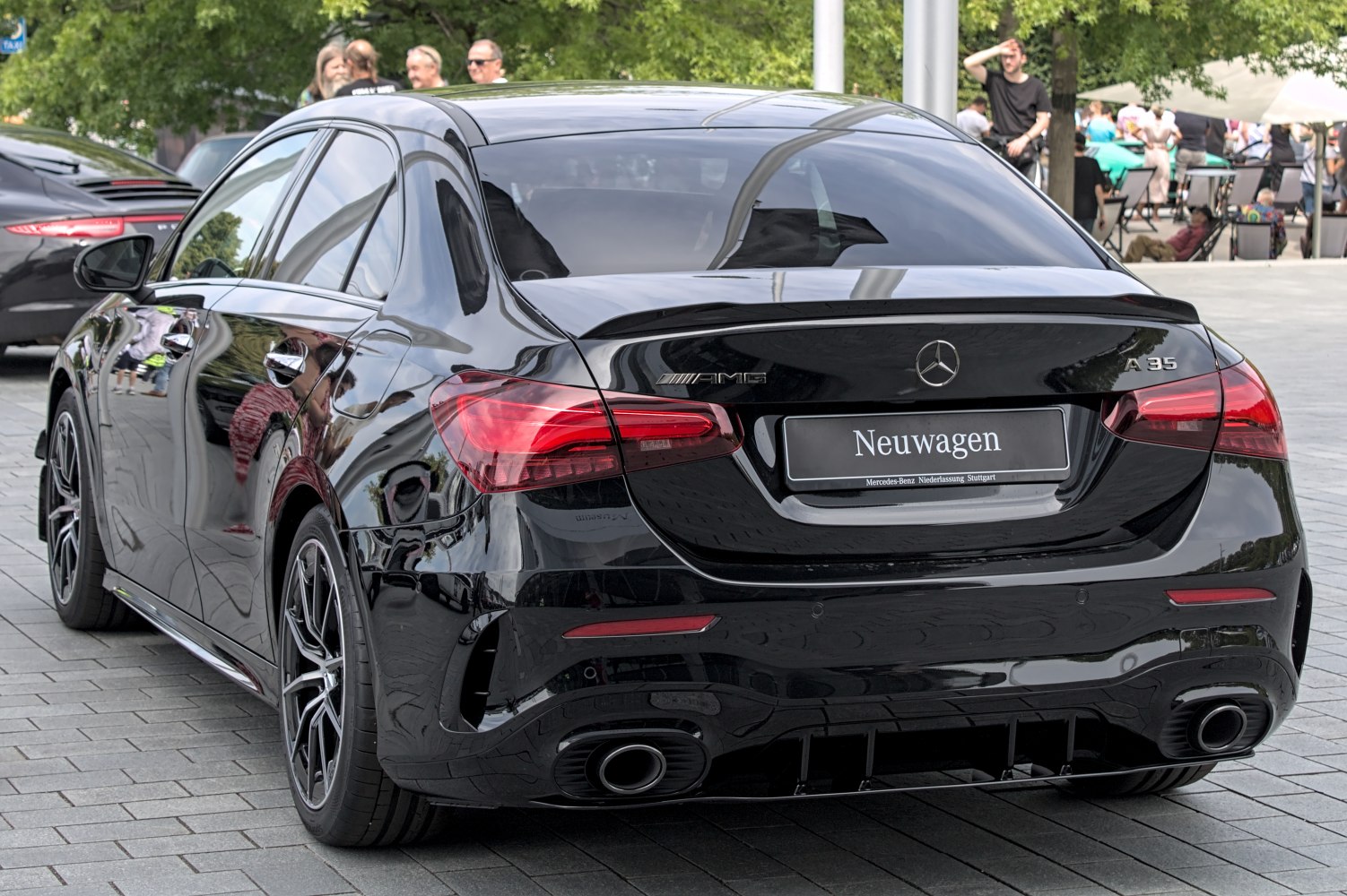 Rear view of a sporty black sedan with dual exhaust and AMG badge
