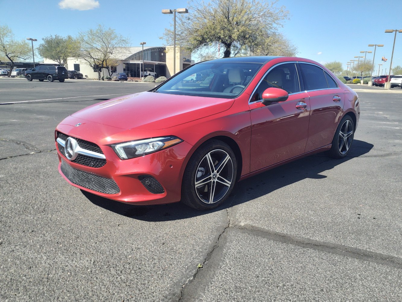 Front side view of a sleek red sedan with alloy wheels