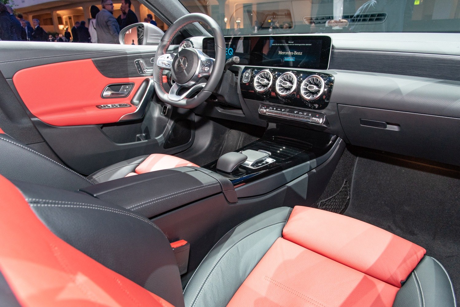 Red leather seats and digital dashboard display inside a modern car interior.