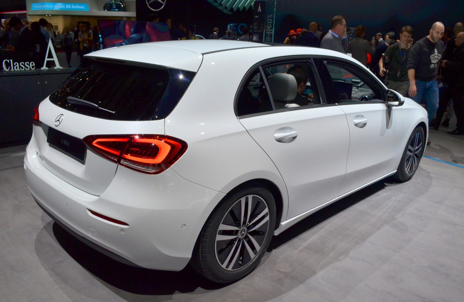 Rear and side view of white hatchback, illuminated taillights