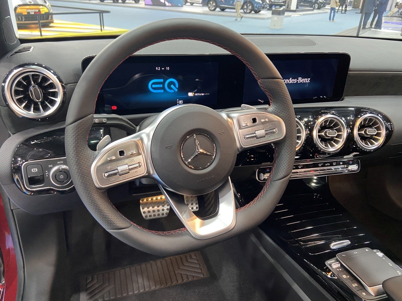Modern digital dashboard and sporty steering wheel with circular air vents.