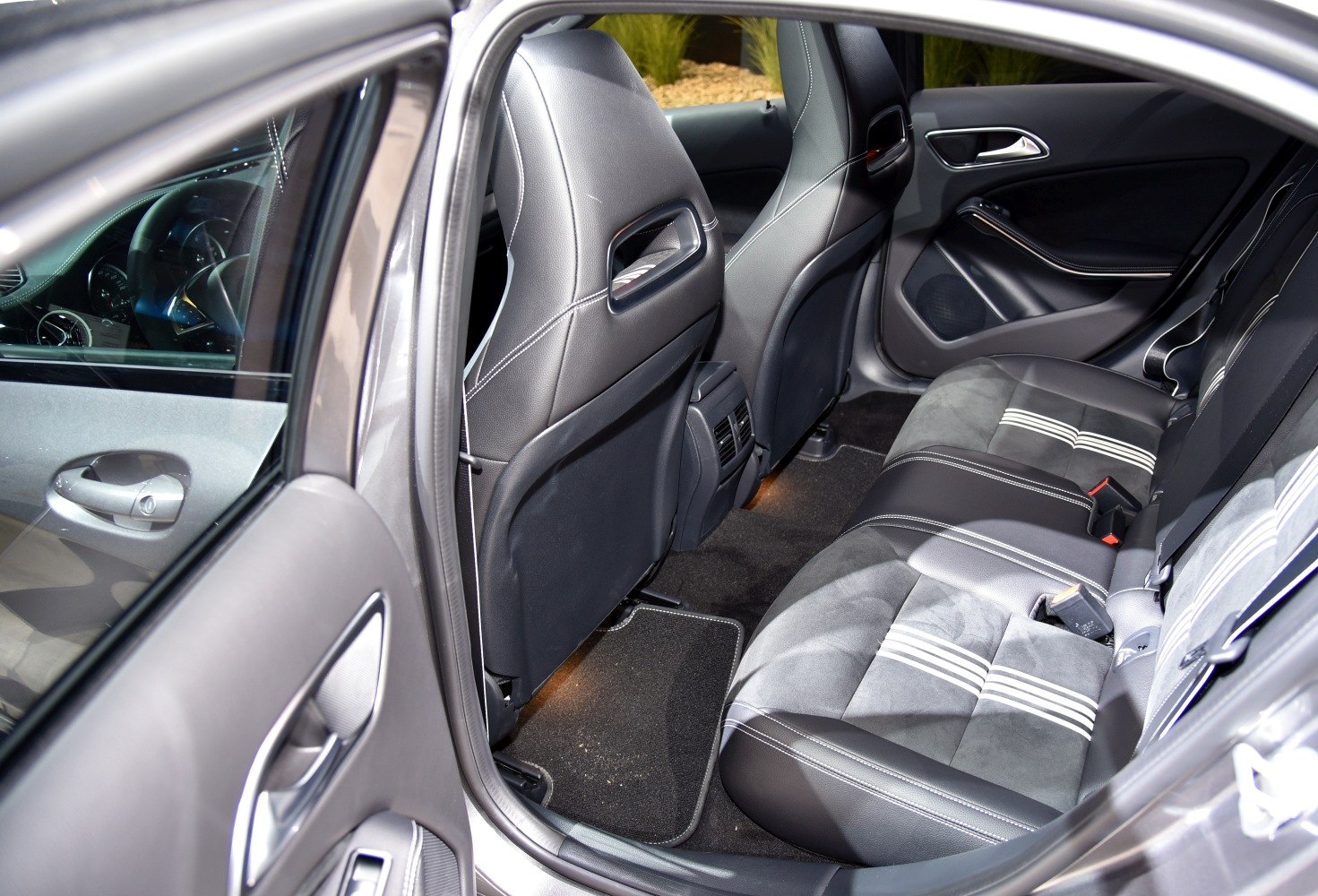 Rear seat interior featuring leather and fabric upholstery with rear air vents and door panel details.