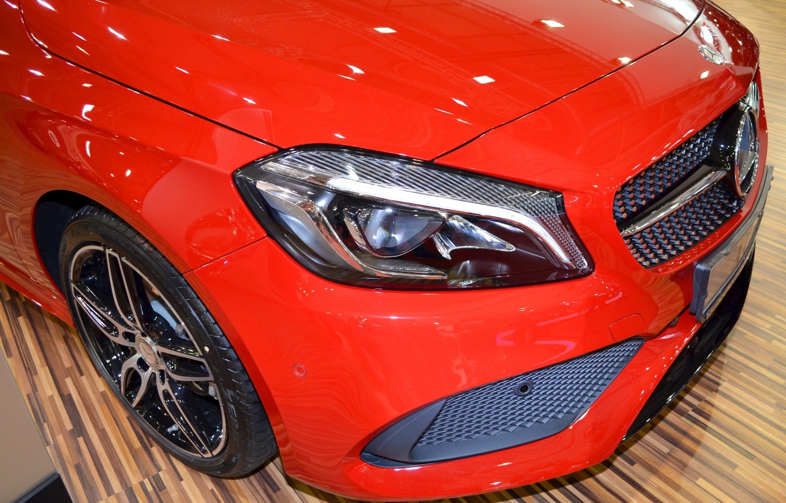 Front headlight and alloy wheel close-up on a red sporty car
