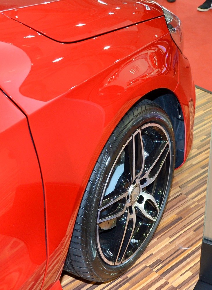 Glossy red fender with black alloy wheel and tire