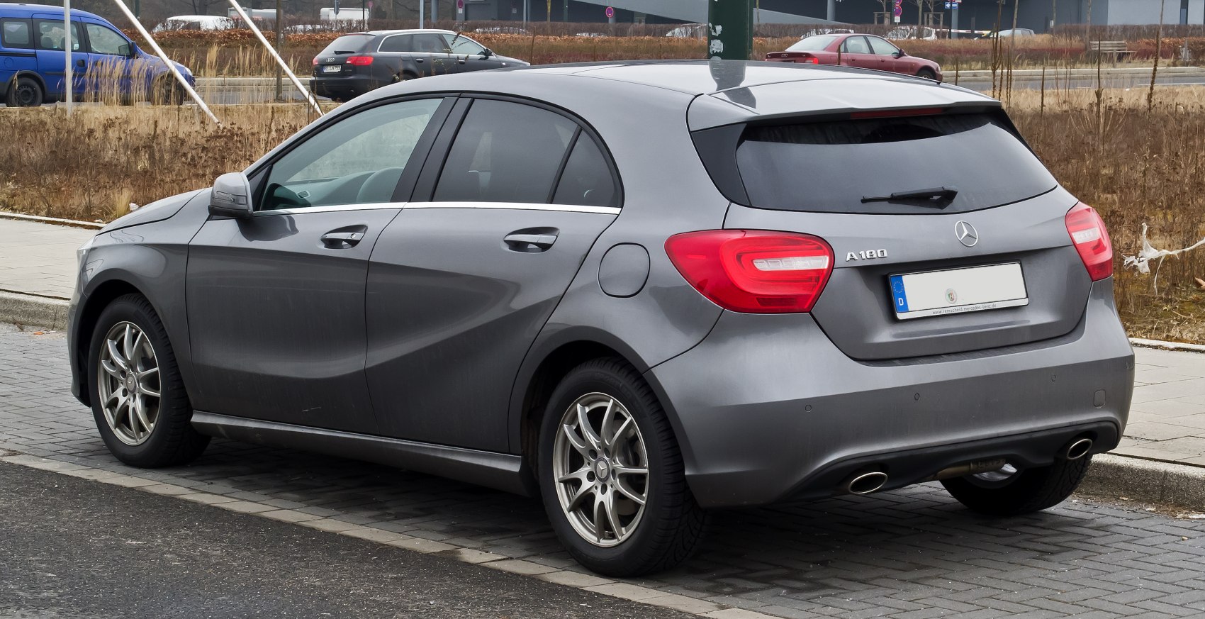 Rear-side view of grey hatchback with dual exhaust and distinct tail lights