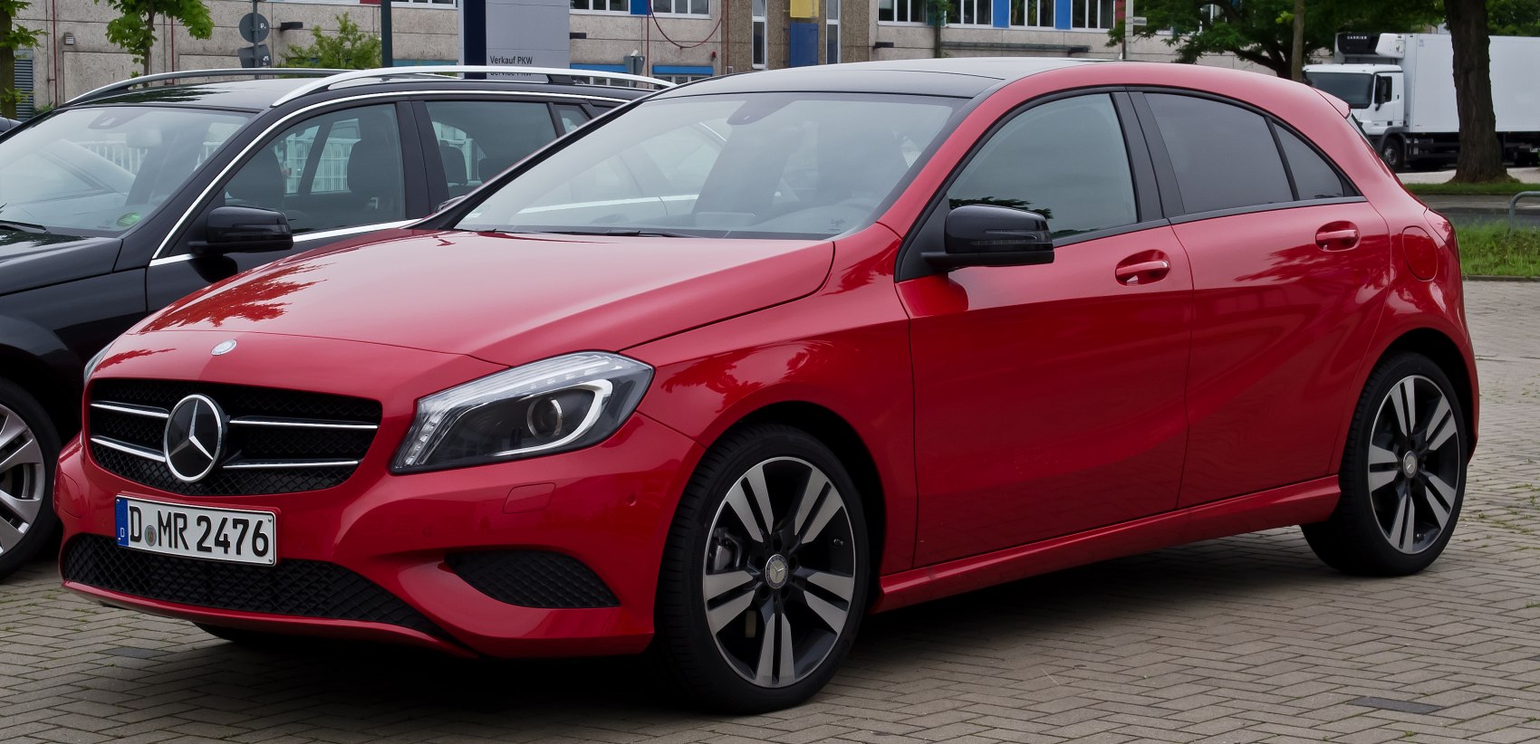 Red modern compact hatchback front side view with sleek headlights and alloy wheels