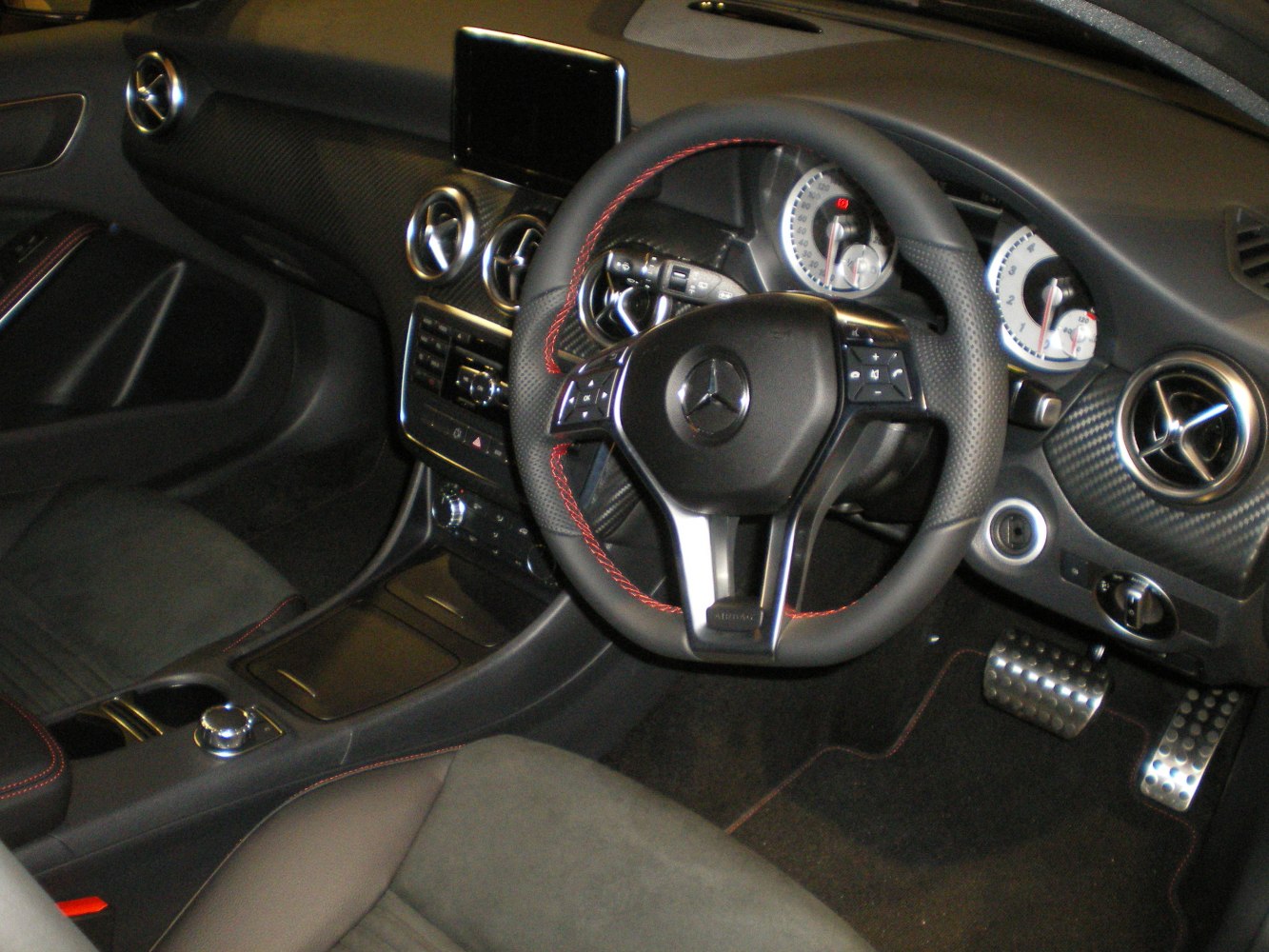 Steering wheel and dashboard with sporty carbon trim and instrument cluster