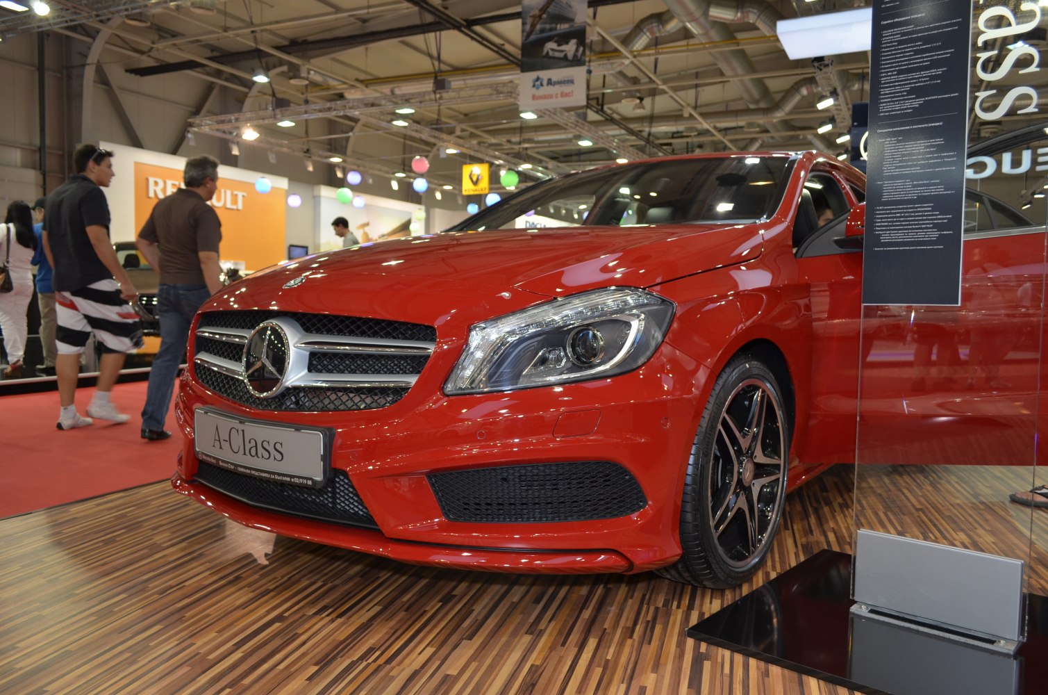 Front grille and headlight design with alloy wheel of a red compact hatchback