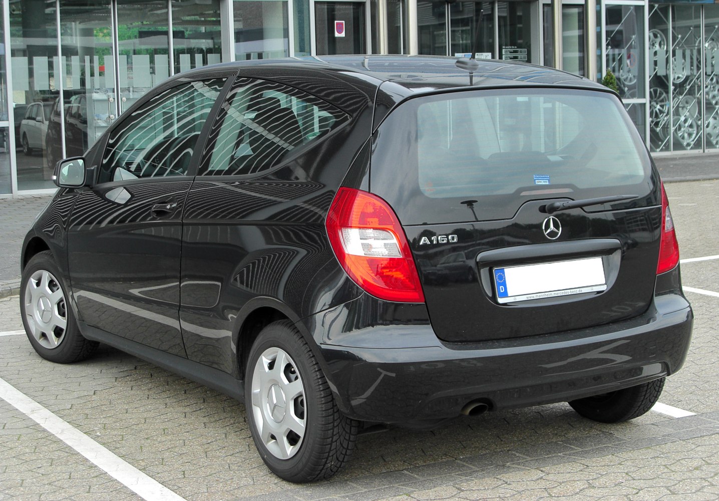 Compact black hatchback rear view with unique tail lights and simple wheel covers