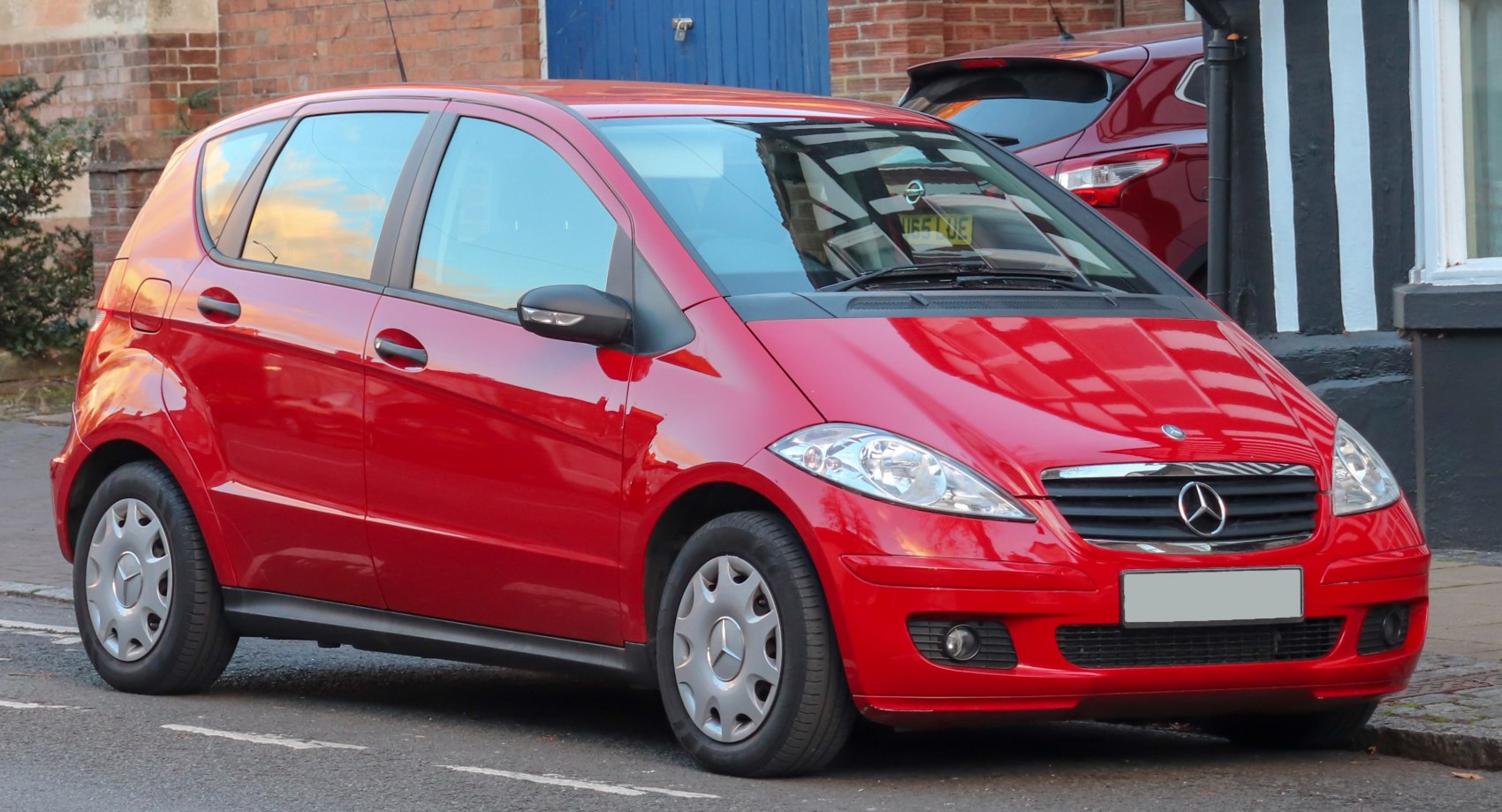 Red hatchback with aerodynamic shape and multi-spoke hubcaps