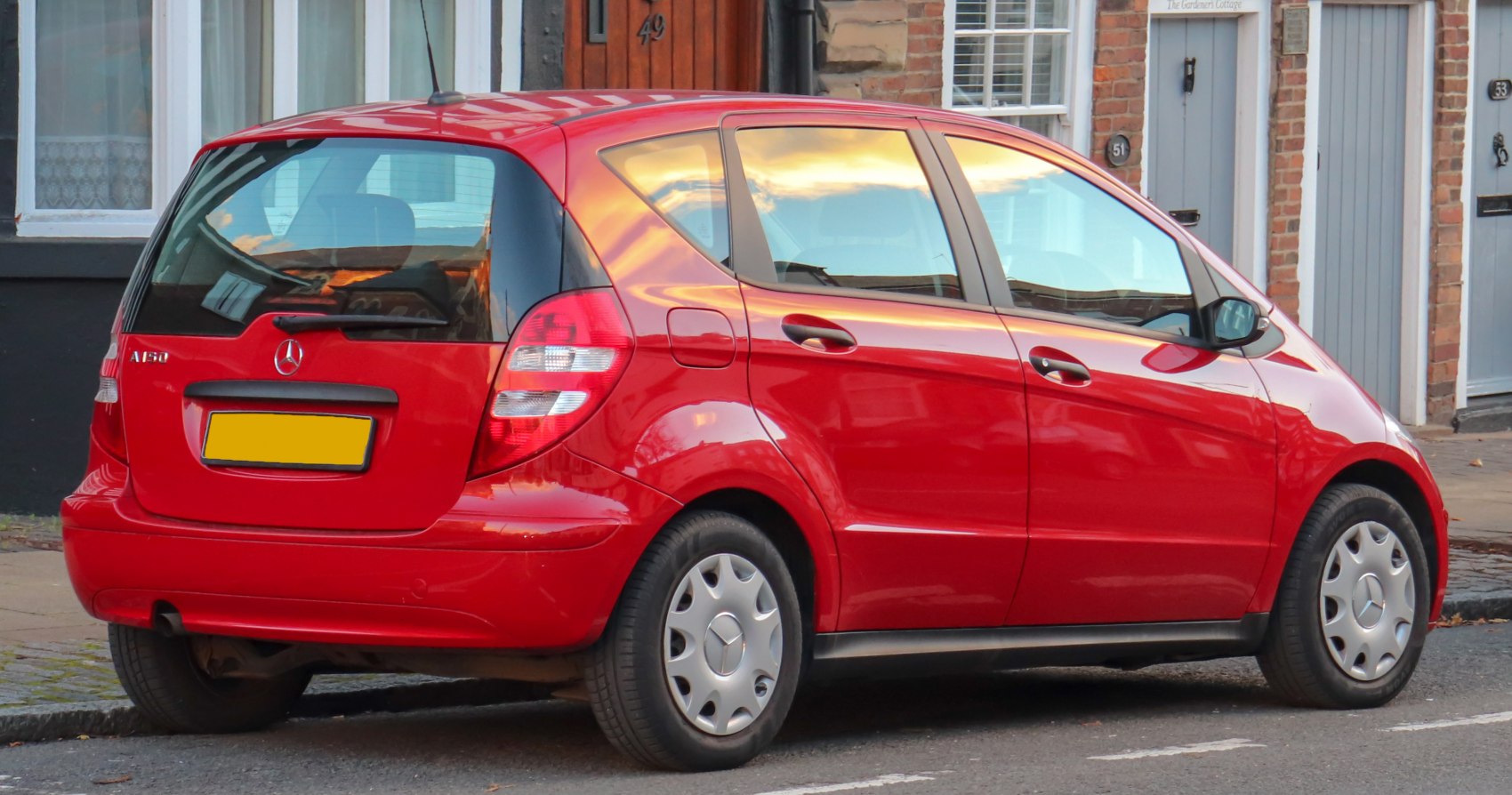 Red hatchback with rear view, five-door design