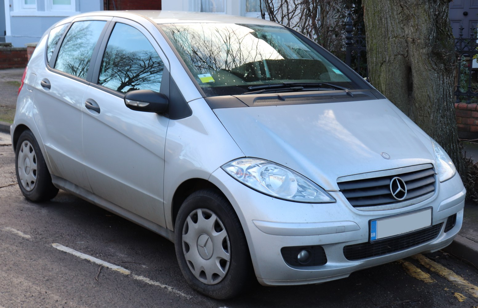 Silver compact hatchback, front side view with distinctive grille and headlamp design.