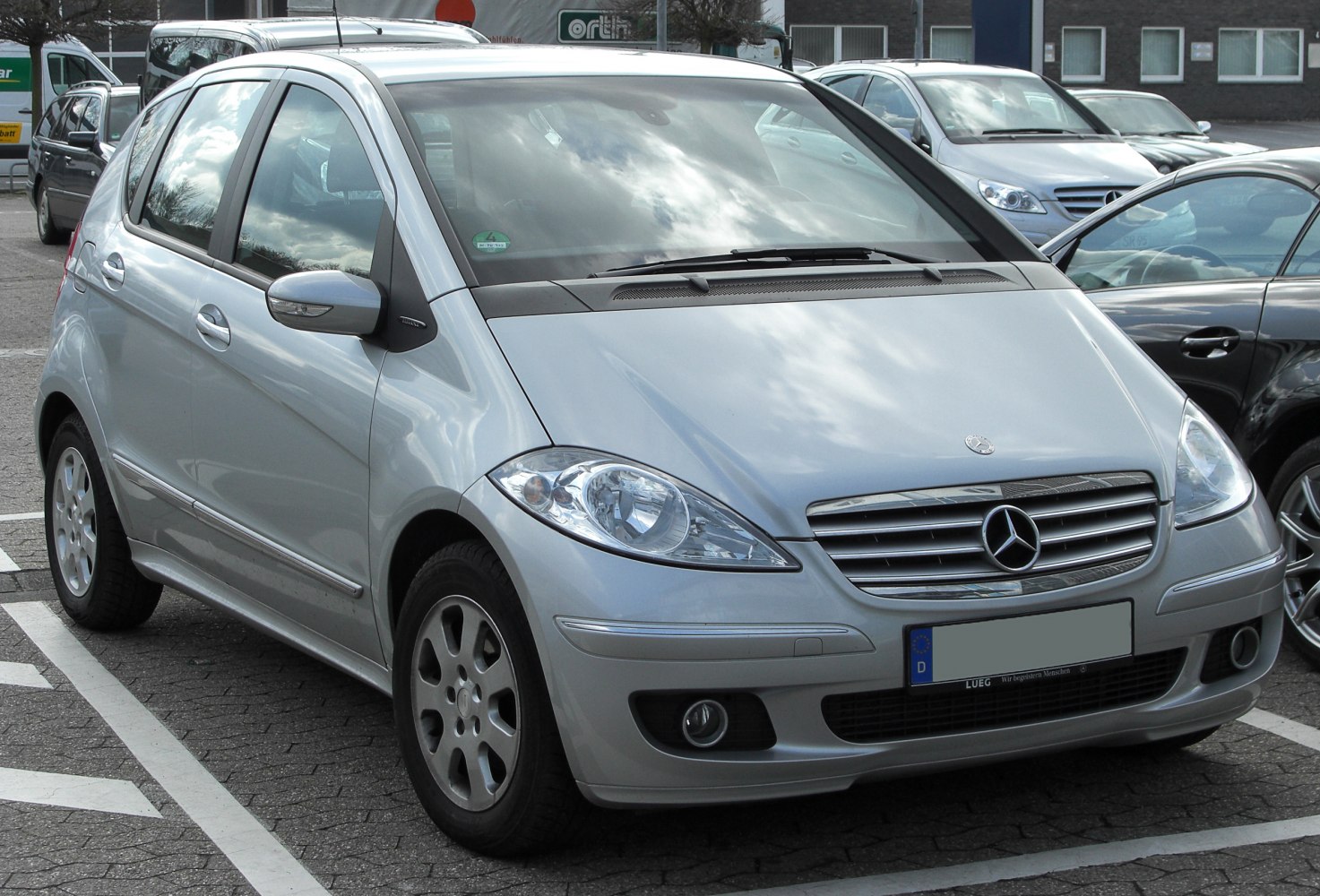 Silver compact hatchback with rounded headlights and chrome grille