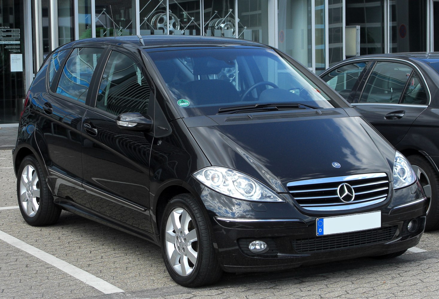 Black hatchback showing front grille, headlamps, and alloy wheels.