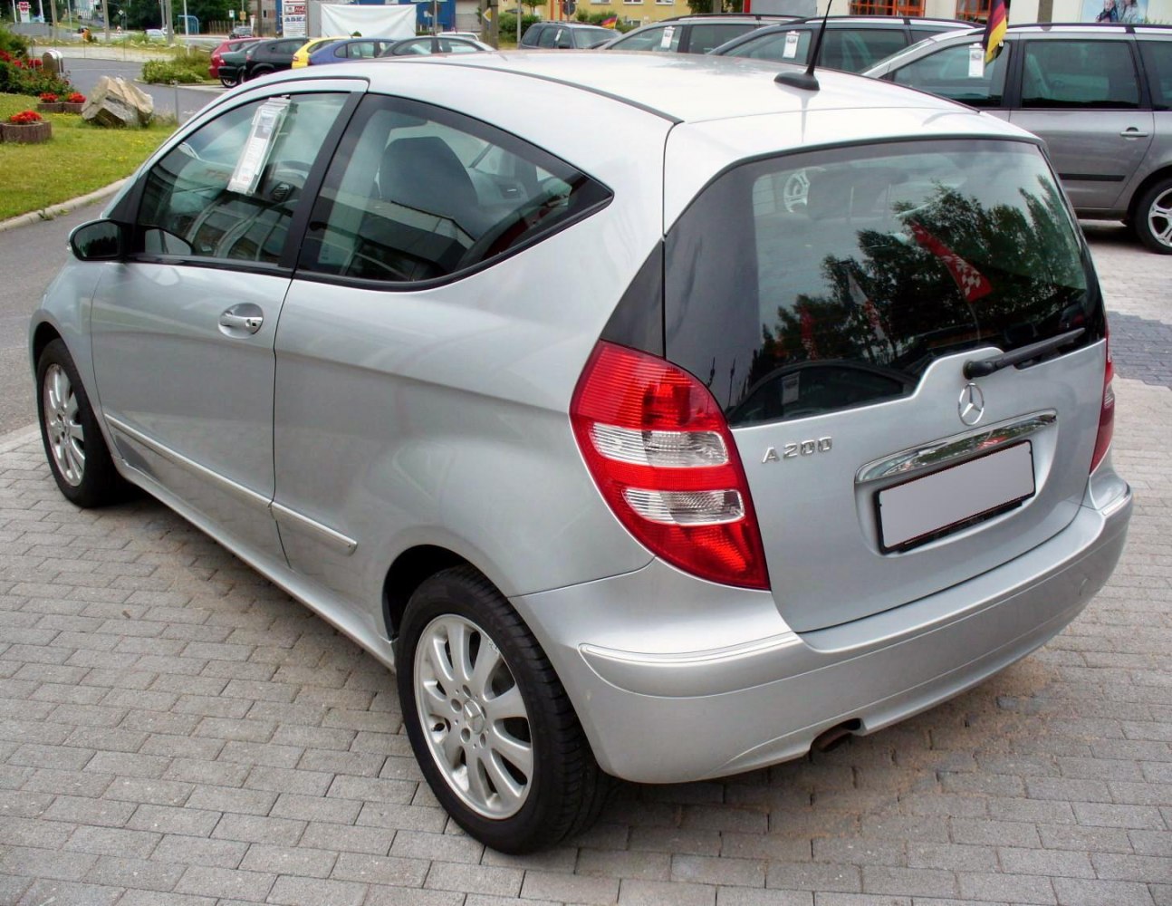 Silver compact hatchback with distinctive taillights and two-door side design