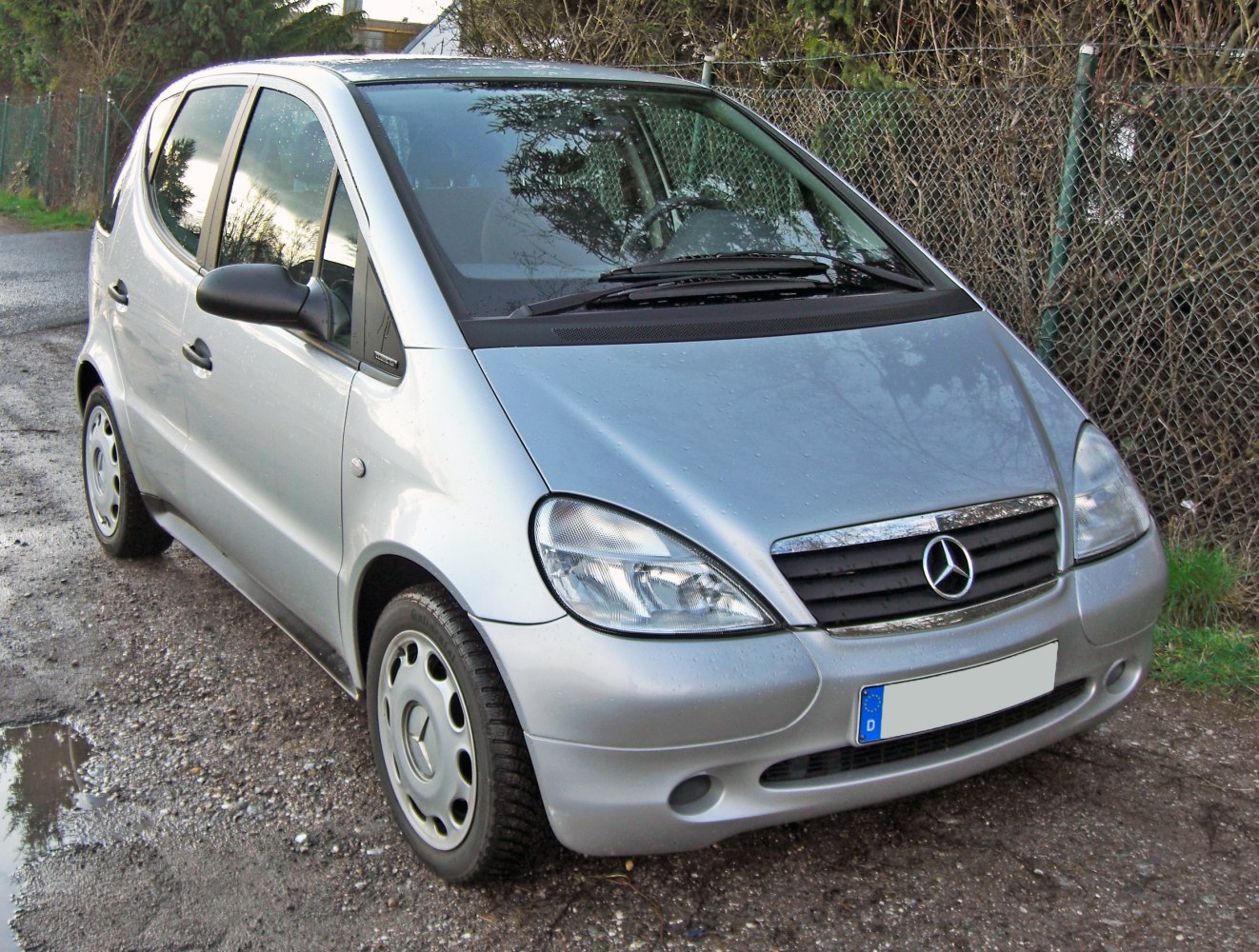 Silver compact hatchback with rounded headlights in front 3/4 view