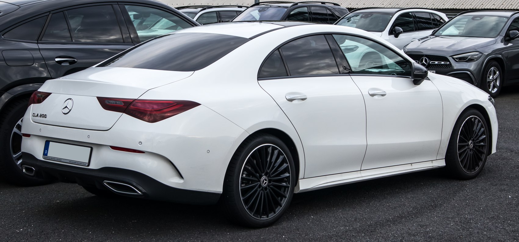 Sleek rear design with black multi-spoke alloy wheels and integrated exhaust tips.