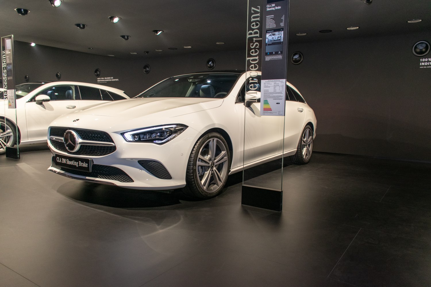 Front profile with sharp headlamps and sporty grille of a sleek white estate.