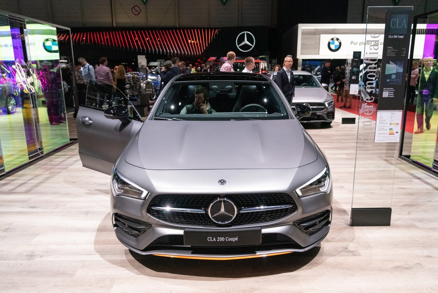 Front view of a luxury coupe with open driver's door and LED headlights