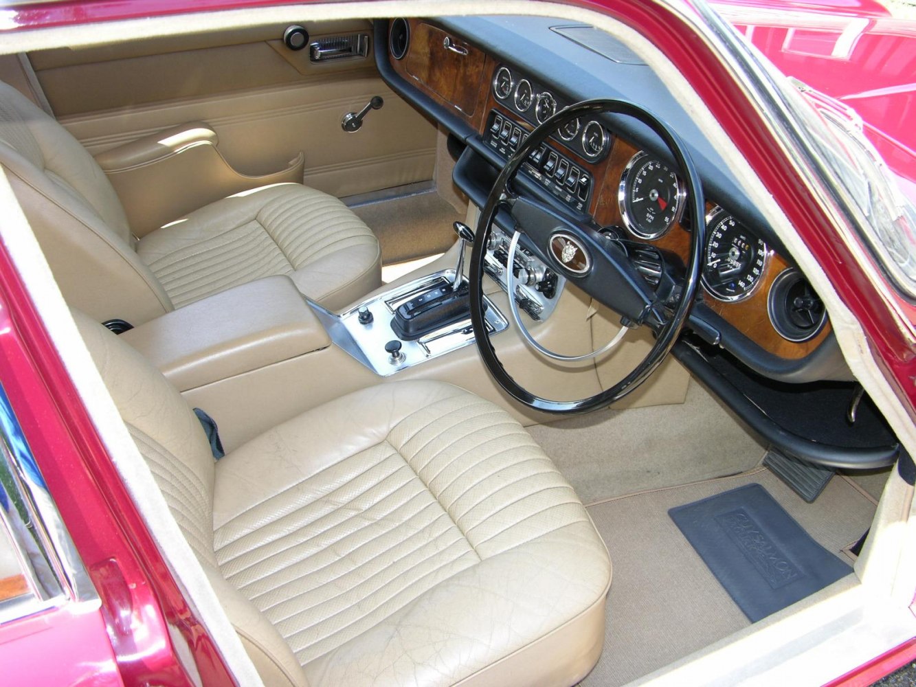 Beige leather seats and wooden dashboard with analog gauges