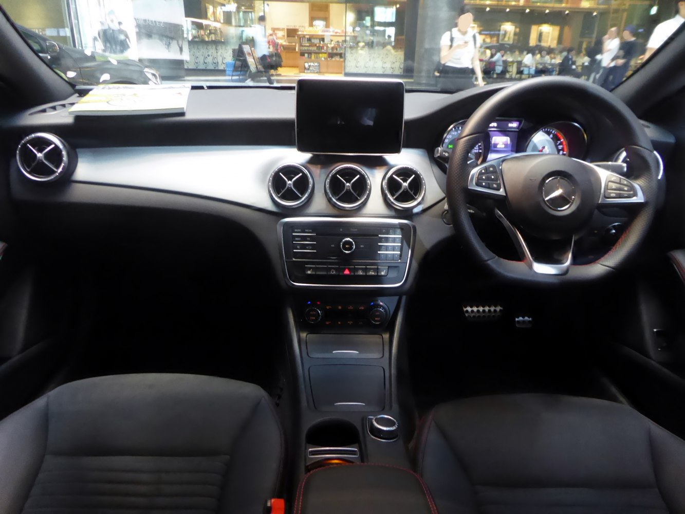 Sporty steering wheel, circular air vents, central multimedia display, sleek dashboard.