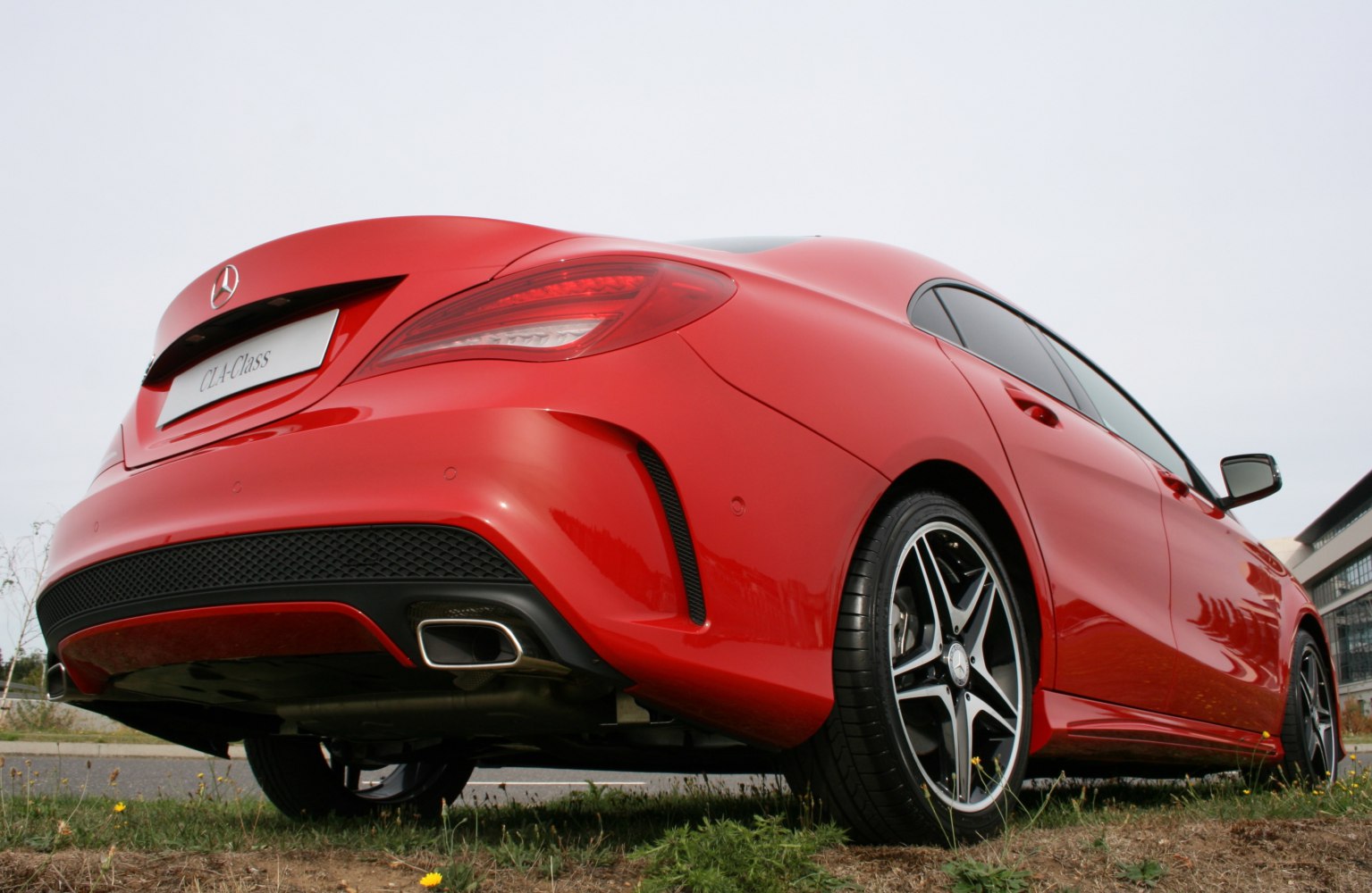 Sleek rear design with tail lights, alloy wheels, and dual exhausts