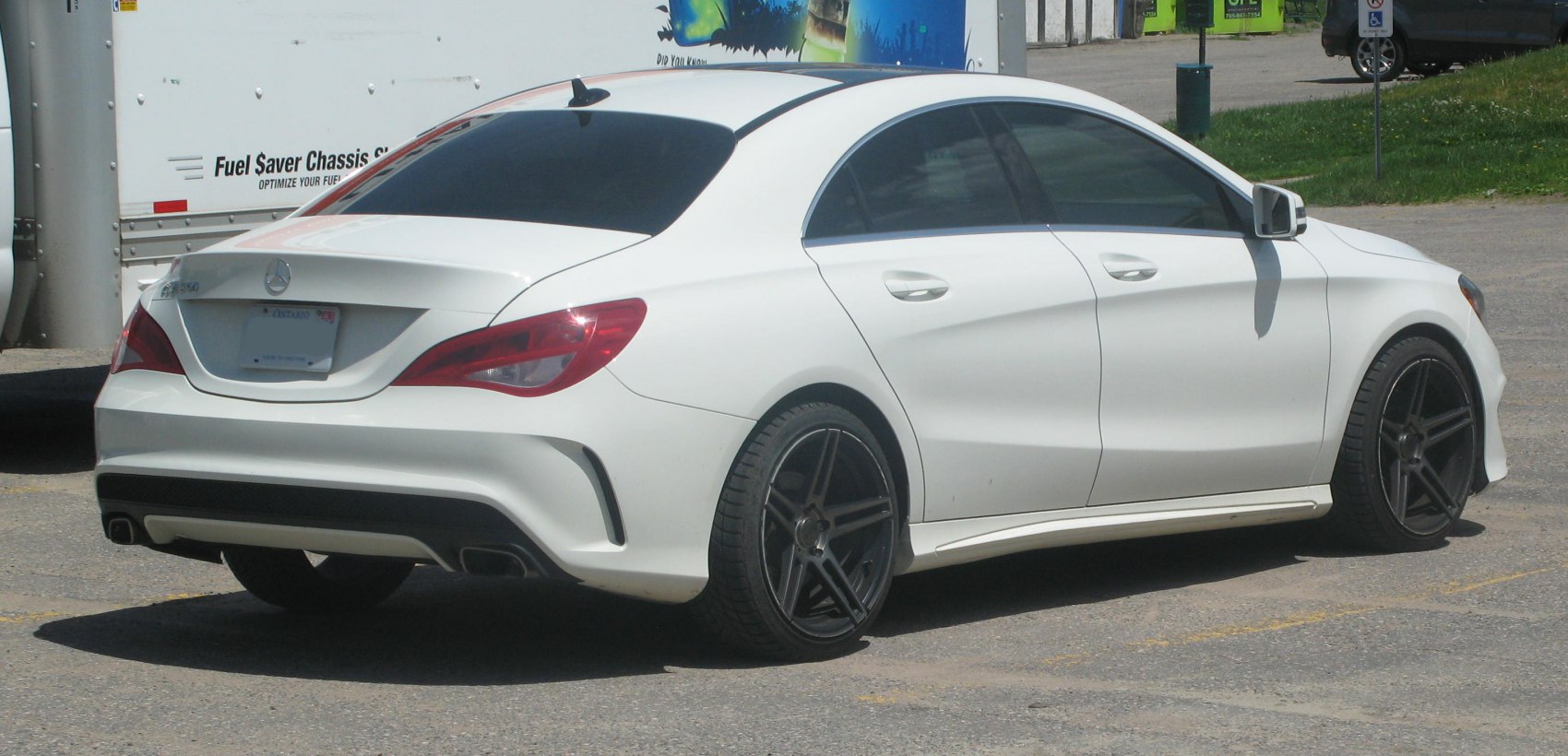 White four-door sedan with black sporty rims and tinted windows
