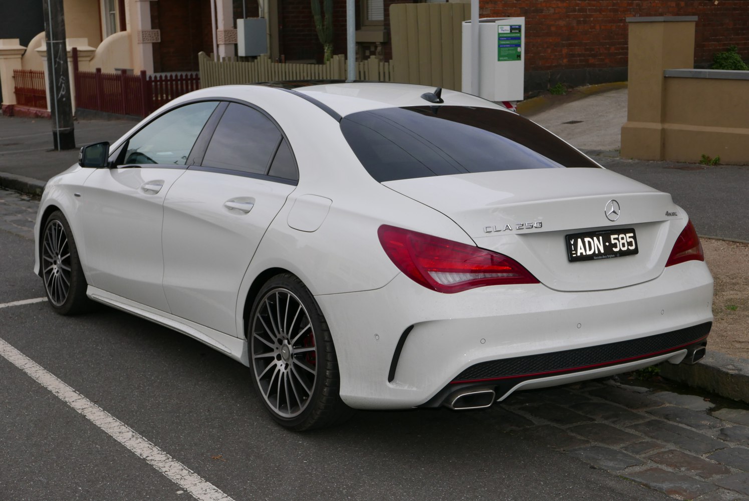 Rear view of white coupe with sporty taillights and dual exhausts