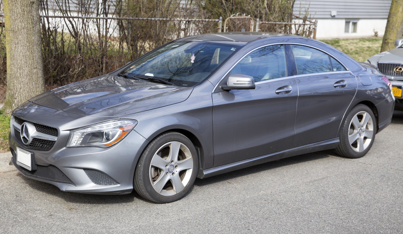 Front side view with sleek headlights and five-spoke alloy wheels