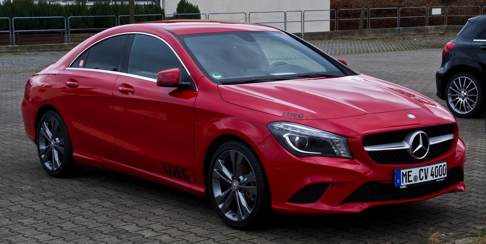 Red sporty sedan with LED headlights and sleek alloy wheels