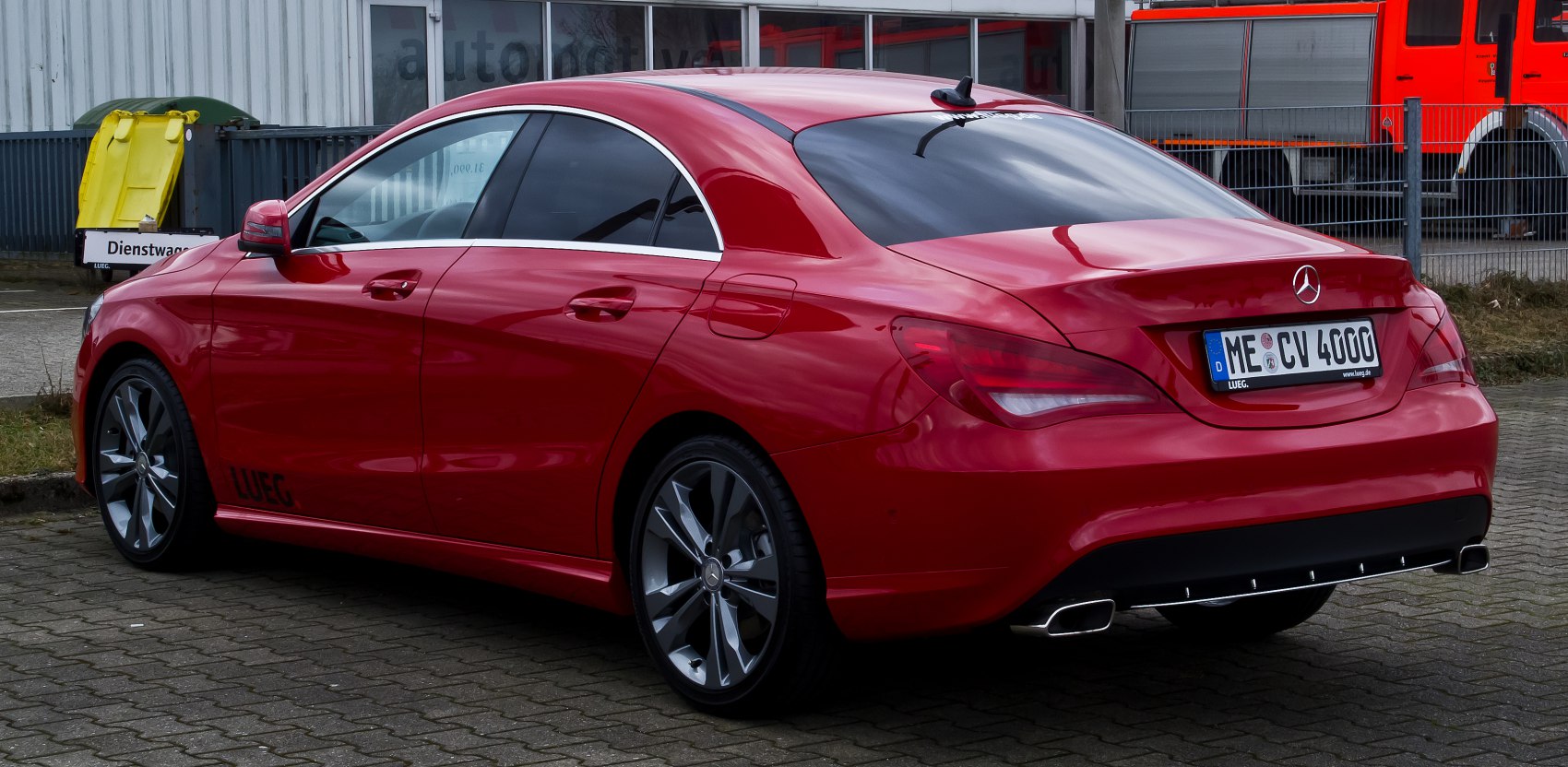 Red sporty coupe with tinted windows and dual rectangular exhausts