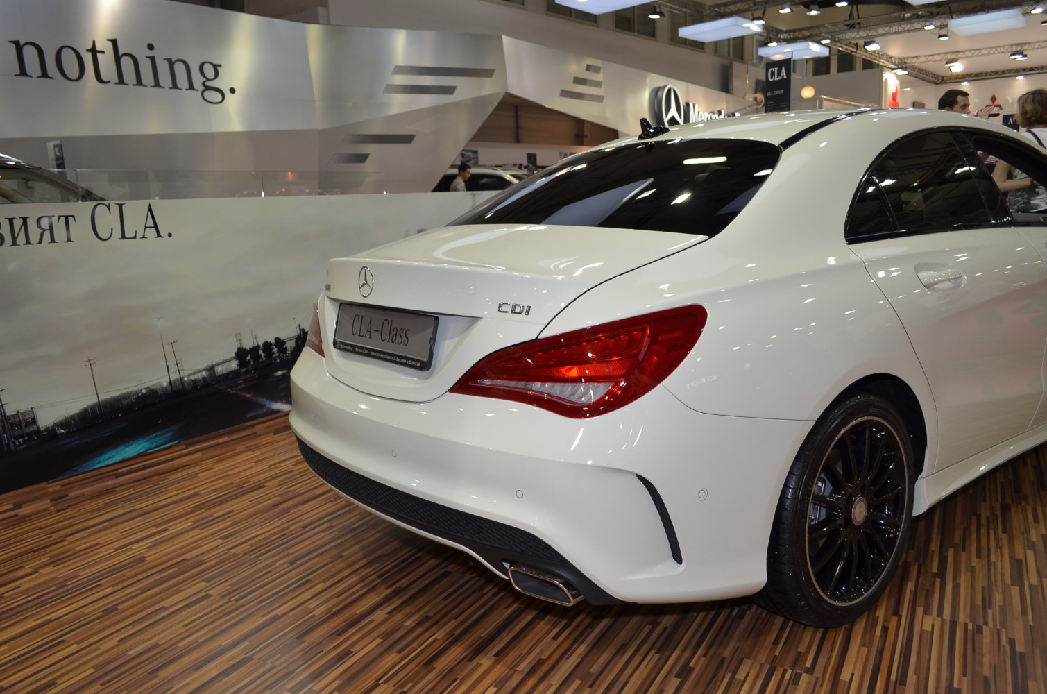 Rear view with tail light and black rims on white coupe