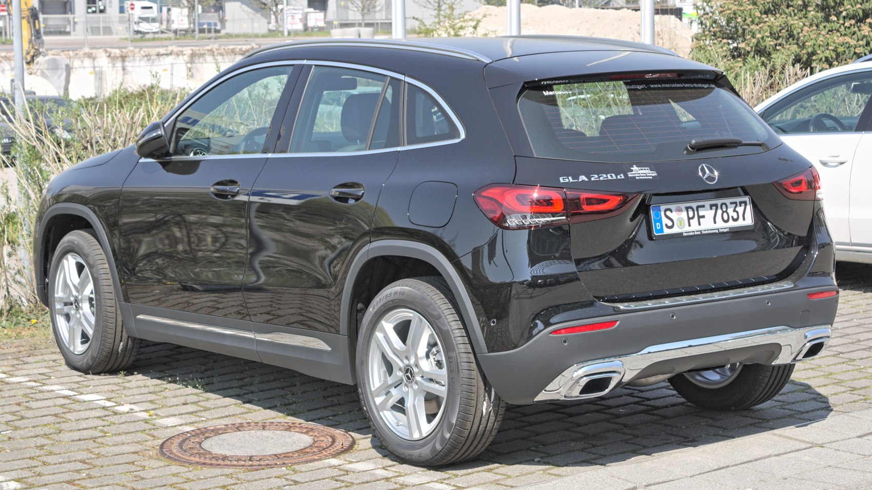 Black compact SUV rear and side view with taillights and chrome exhaust
