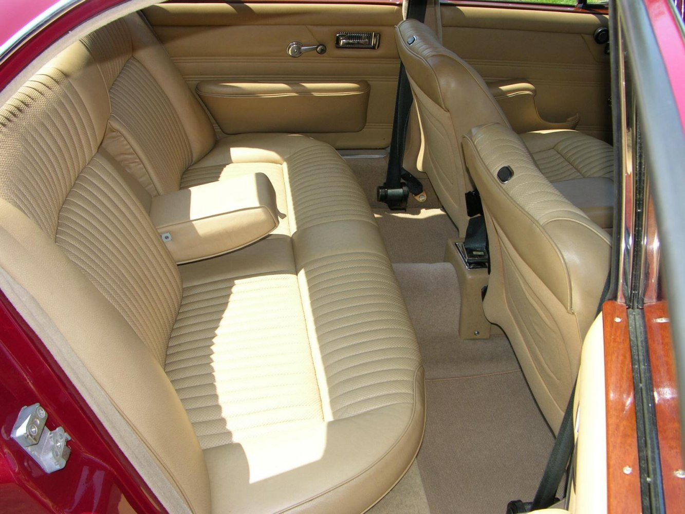 Beige leather rear bench seat with armrest and detailed door panel