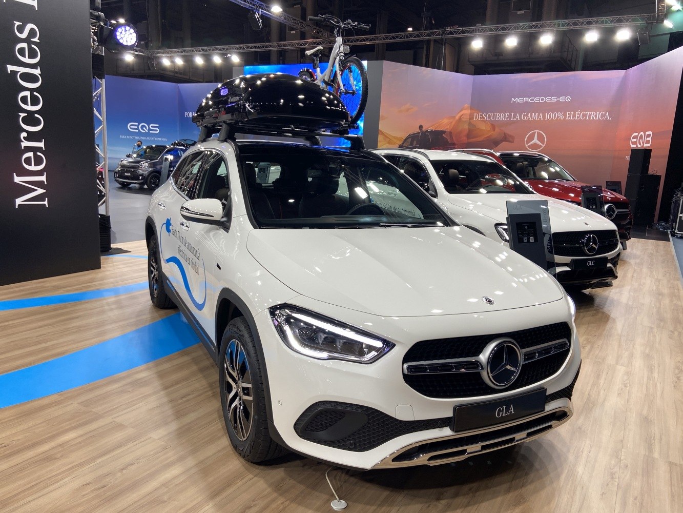 White SUV with rooftop cargo box and bicycle