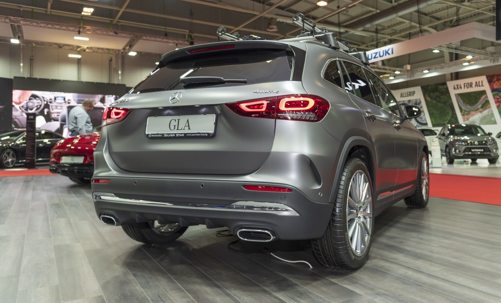 Rear view with LED tail lights, dual exhaust, and roof rack