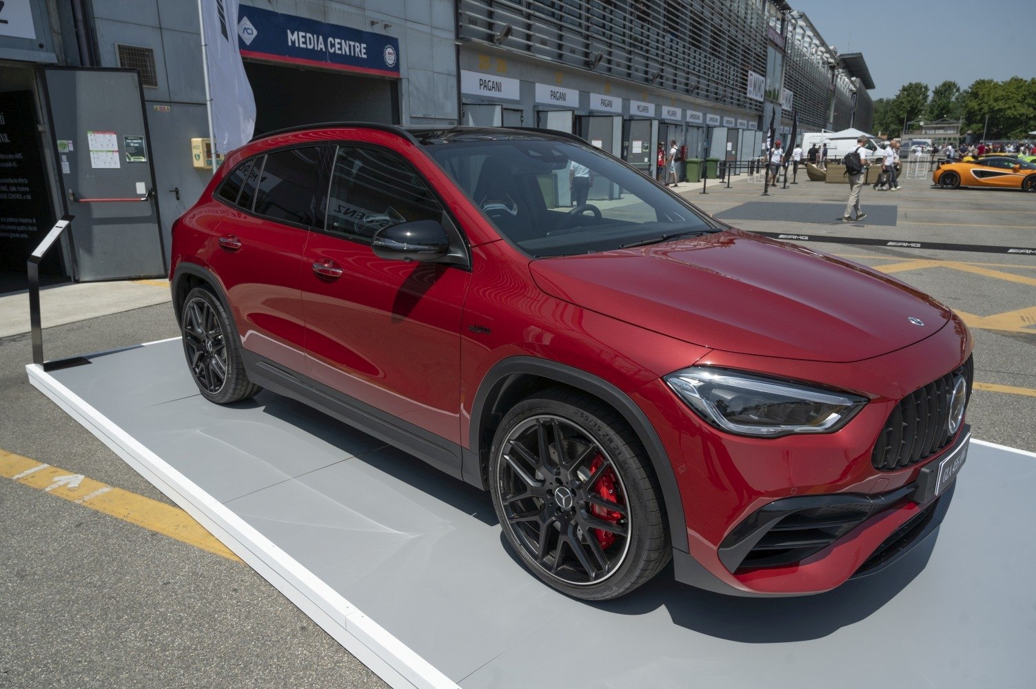 Red sporty SUV with black AMG wheels and aggressive front fascia