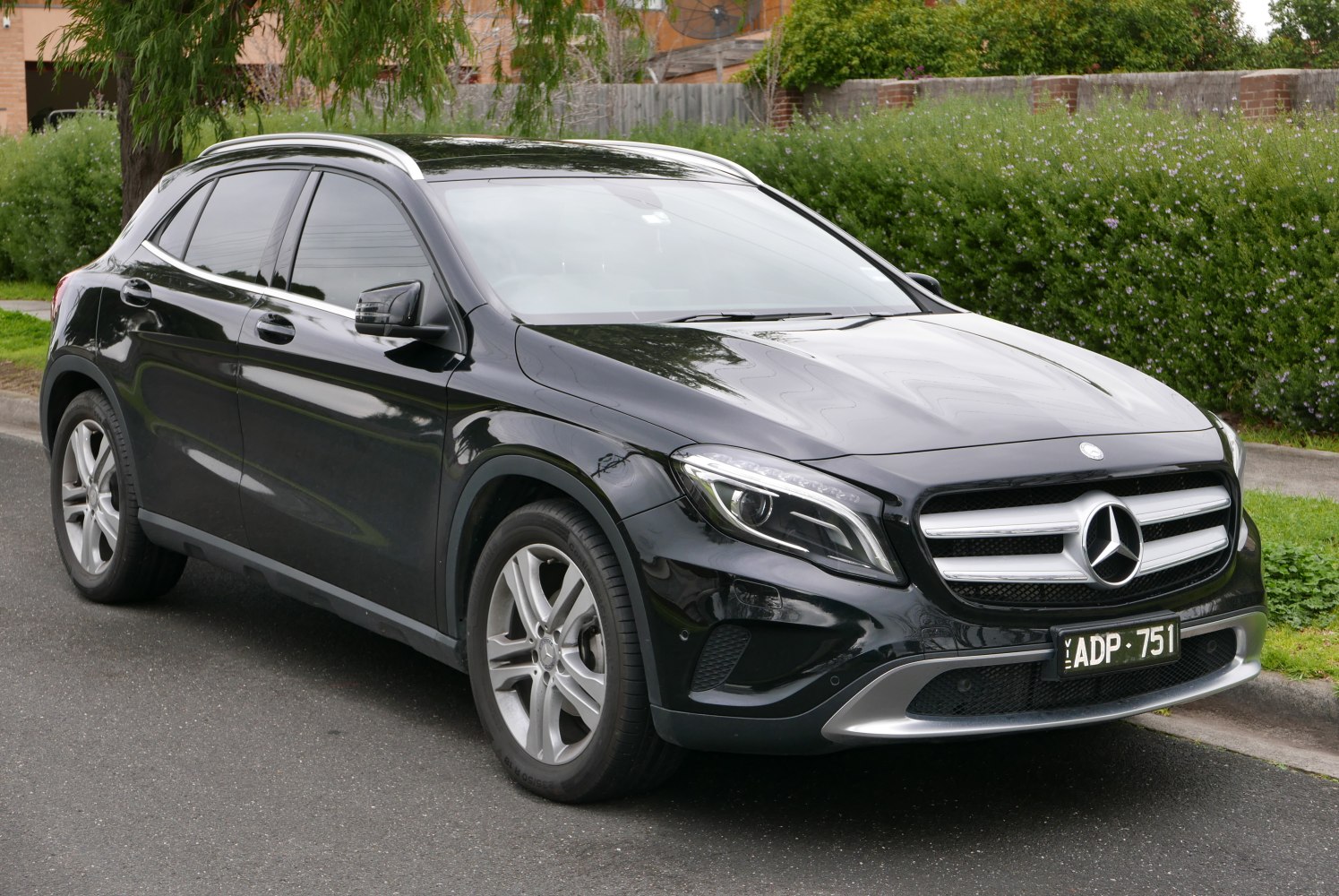 Front side view of black compact luxury SUV with LED headlights and roof rails
