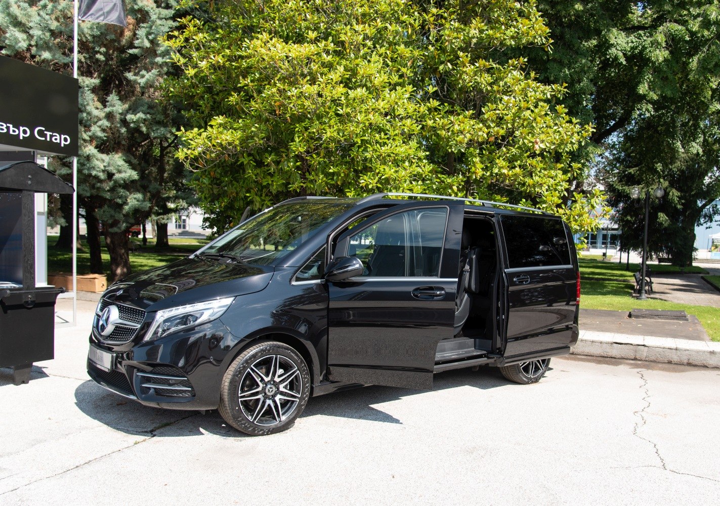 Black luxury van side profile with open sliding door and alloy wheels