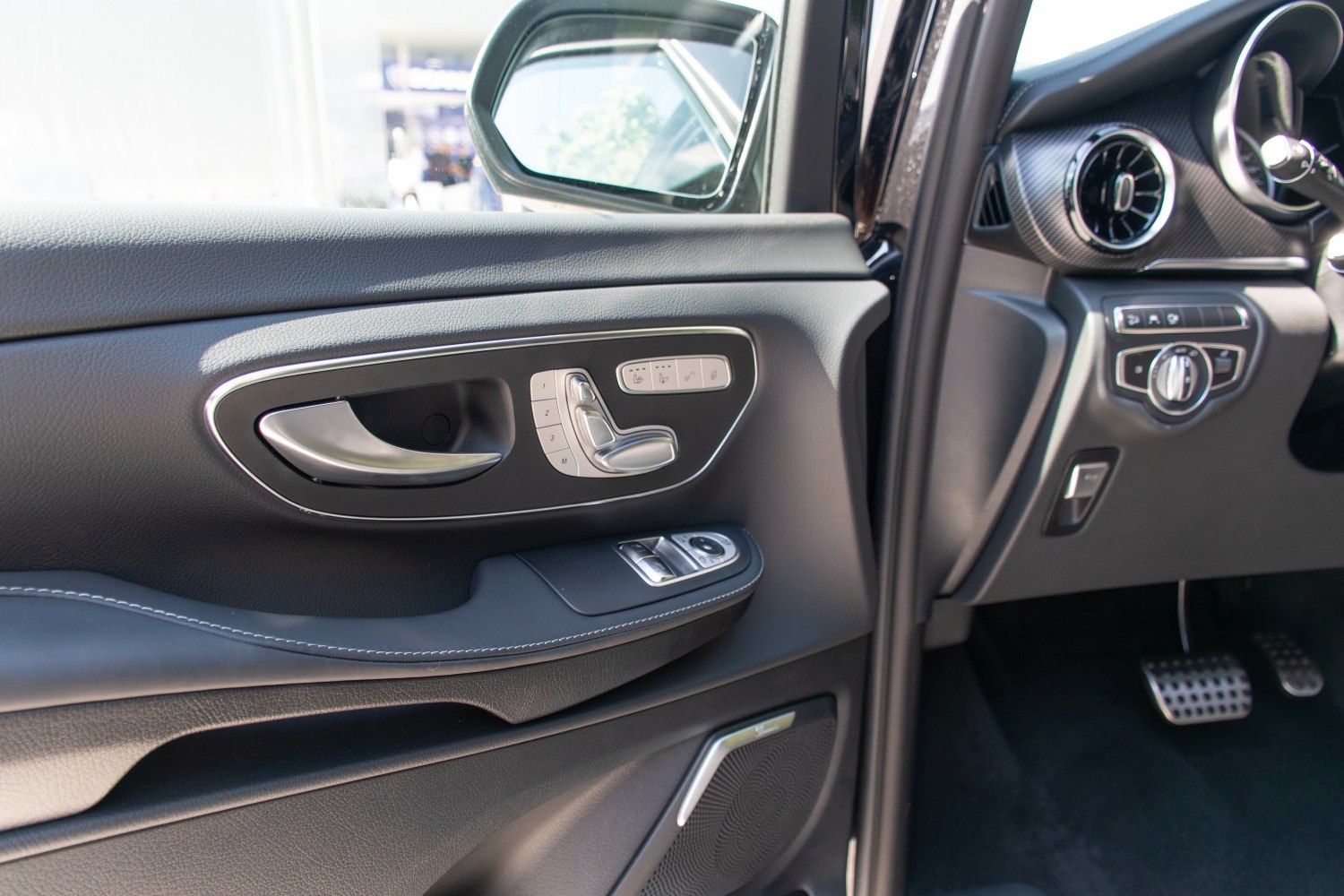 Interior door panel with seat adjustment and window controls
