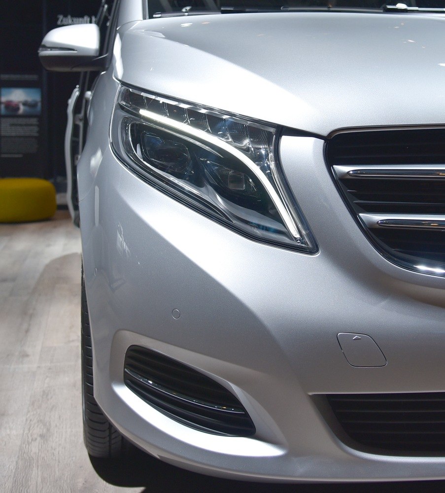 LED headlight and front grille of a silver vehicle