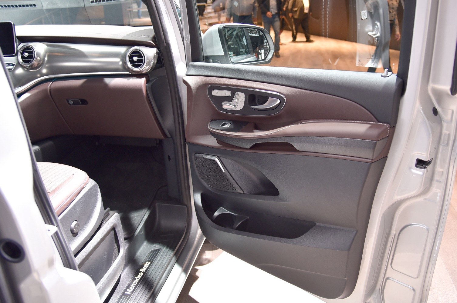 Luxurious car door panel and polished metal dashboard interior features.